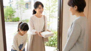 子どものトラブルで親子が菓子折りを持って丁寧に謝罪しているイメージ
